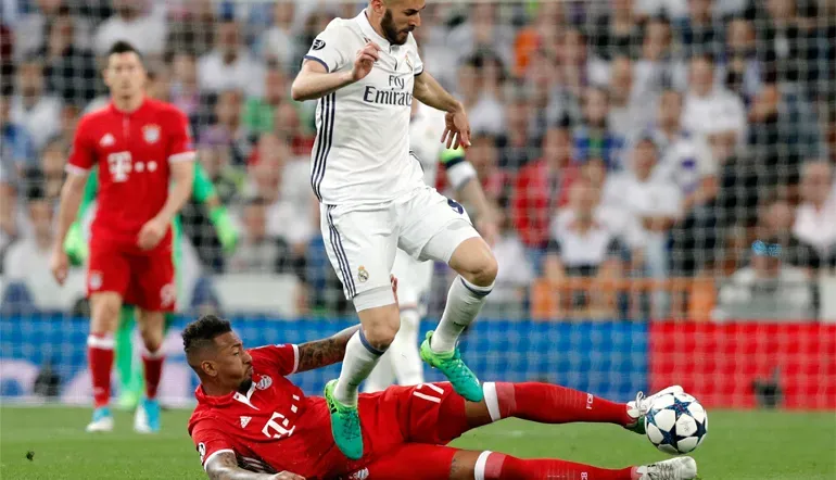 Jerome Boateng klärt den Ball im Zweikampf mit Reals Benzema